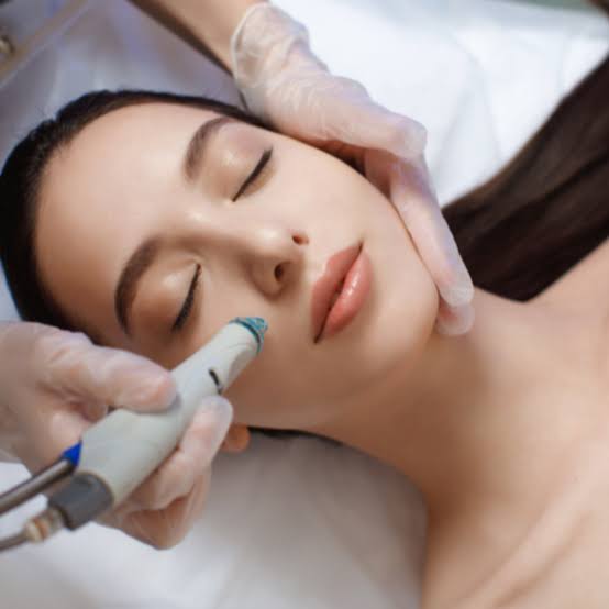 Soin Hydrajet : la praticienne passe l’embout sur la joue d’une cliente