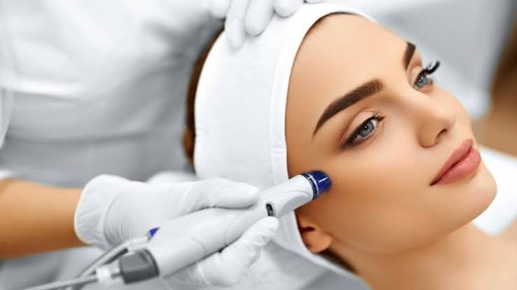 Soin Hydrajet : embout de l’appareil passé sur la tempe d’une cliente allongée